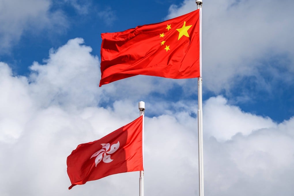 The Chinese (R) and Hong Kong (L) flags are seen hoisted at the end of a flag-raising ceremony to mark the 23rd anniversary of Hong Kong’s handover from Britain in Hong Kong on July 1, 2020. - Hong Kong marked the 23rd anniversary of its handover to China on July 1 under the glare of a new national security law imposed by Beijing, with protests banned and the city’s cherished freedoms looking increasingly fragile. (Photo by Anthony WALLACE / AFP)