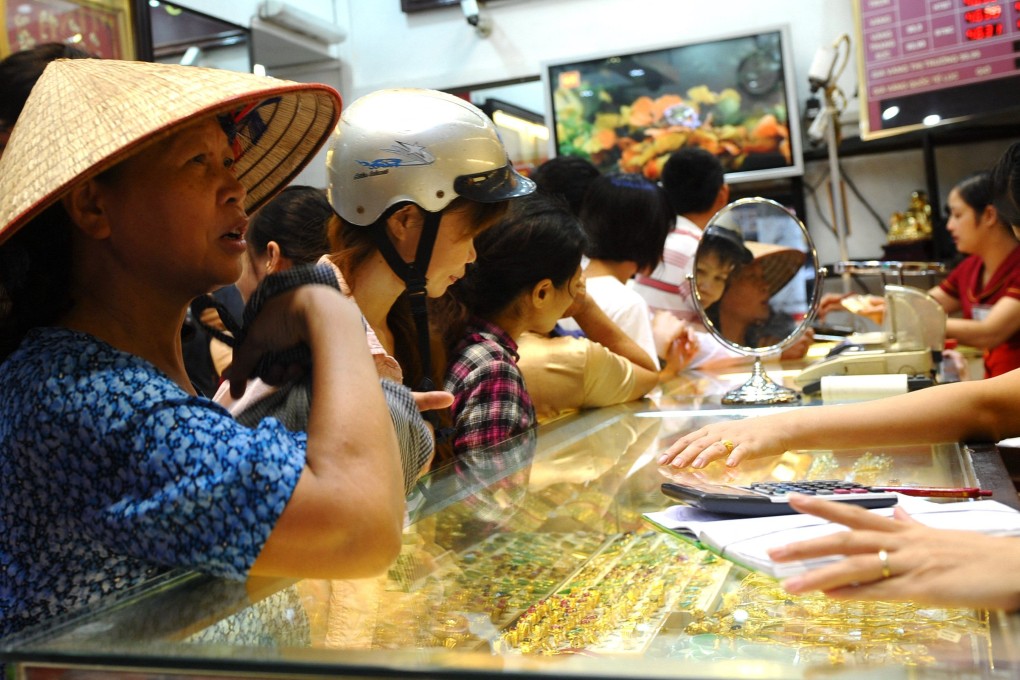Customers buy and sell gold at a local gold shop in Hanoi, Vietnam. Photo: AFP