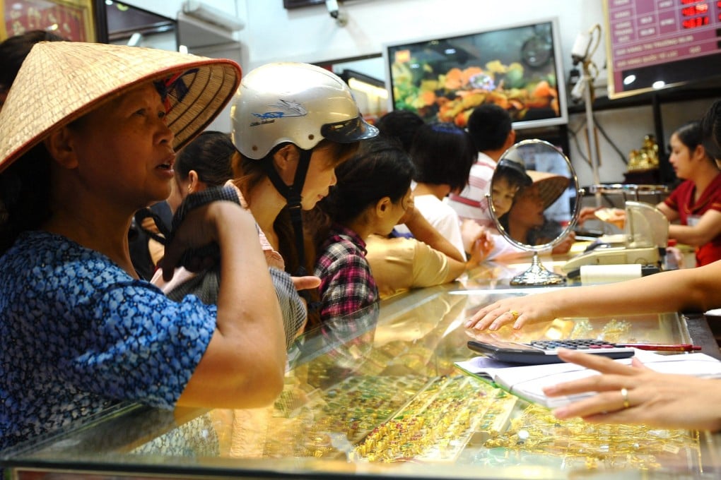 Customers buy and sell gold at a local gold shop in Hanoi, Vietnam. Photo: AFP