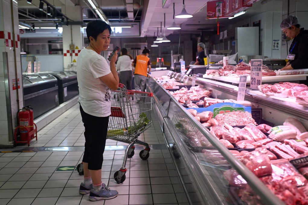 A woman selects pork products at a supermarket in Beijing. Photo: AFP