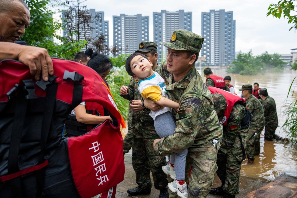 Residents are evacuated from a flooded village in Pingjiang county, Hunan province on Monday. Photo: Xinhua