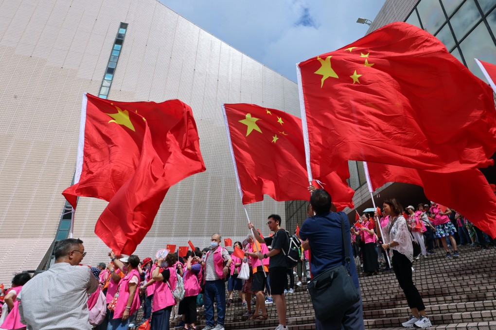 People hold regional and national flags outside the Cultural Centre in Tsim Sha Tsui to celebrate the 27th anniversary of the handover of Hong Kong. Photo: Jelly Tse