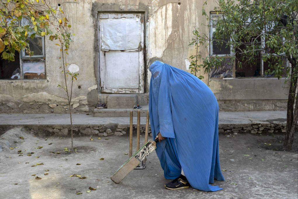 An Afghan woman posing with her cricket bat in Kabul, Afghanistan in 2022. The ruling Taliban have banned women from competitive sports as well as most schooling and many realms of work. Photo: AP