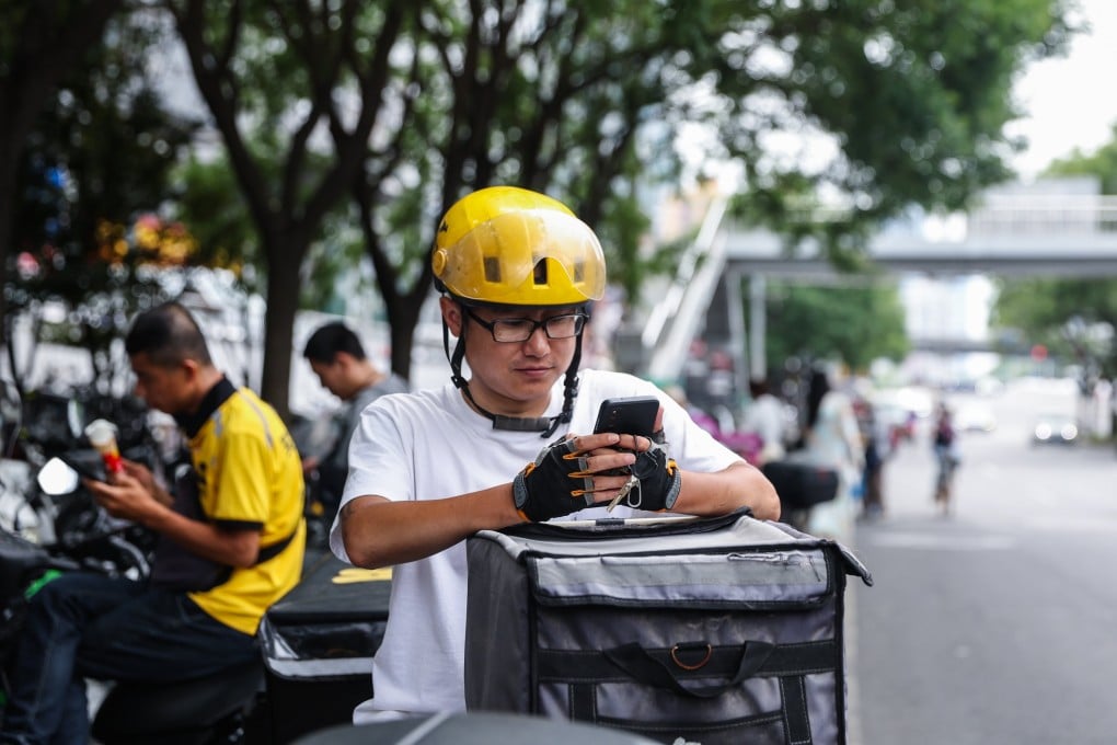 A delivery man uses his cellphone on a street in Beijing. Photo: EPA-EFE