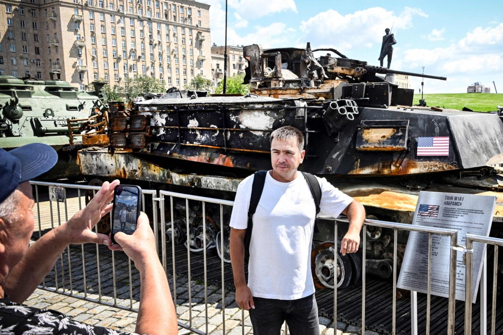 People pose in front of a US tank captured by Russian forces in Ukraine, displayed at a war memorial complex in western Moscow on June 27. Photo: AFP