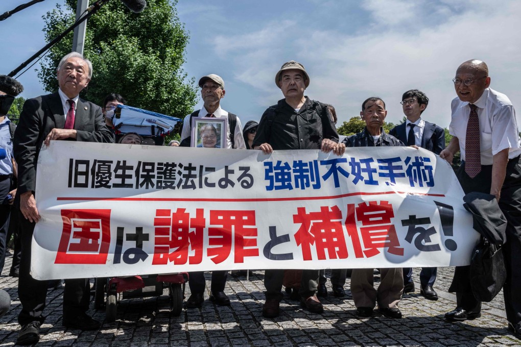 Lawyers and supporters of victims of forced sterilisation under a now-defunct eugenics law, carry a banner demanding apologies and compensations in Tokyo on Wednesday. Photo: AFP
