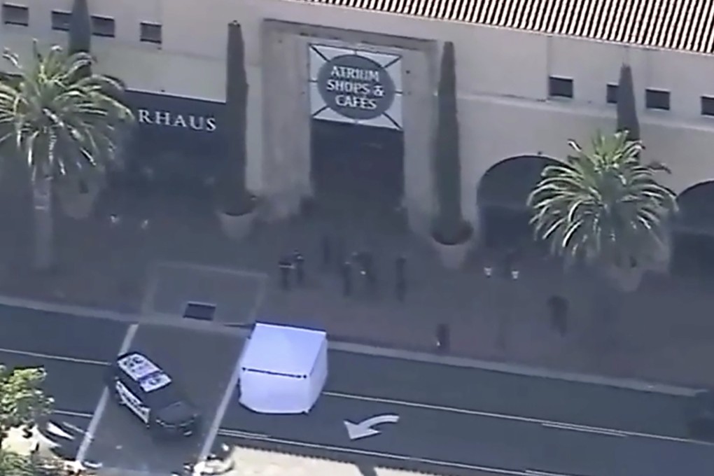 Law enforcement officials outside the mall where a tourist was struck and killed by a car after a botched robbery in Newport Beach, California. Photo: KABC-TV via AP