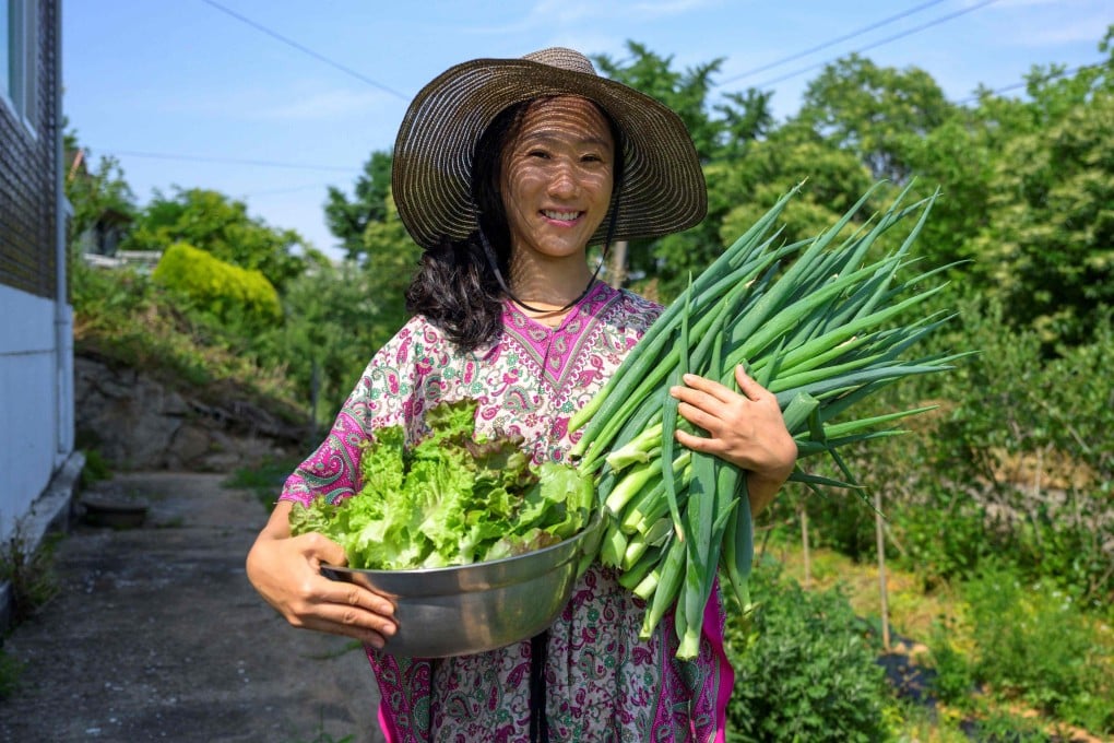 Seen Aromi holds freshly harvested vegetables outside her home in Gyeonggi province. The South Korean YouTube star says people should not feel guilty about being unmarried and childless, even as South Korea experiences the world’s lowest birth rate. Photo: AFP