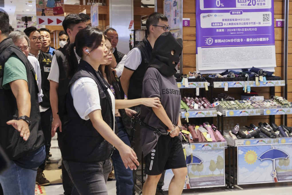 Police officers escort a woman detained in connection with the kidnapping of a child to a reconstruction at the TKO Plaza shopping centre in Tseung Kwan O. Photo: Jelly Tse