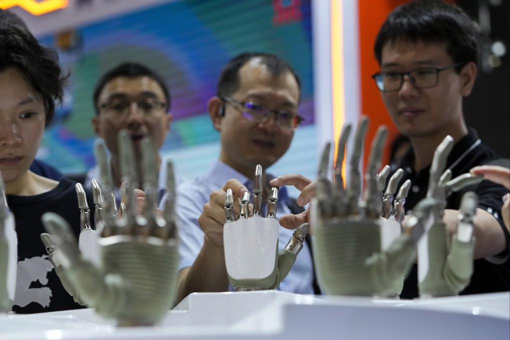 Visitors touch the humanoid robot hands on display at a booth during the World Artificial Intelligence Conference (WAIC) in Shanghai China, July 4, 2024. Photo: AP