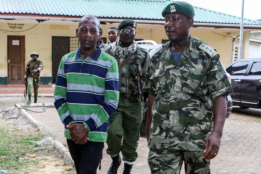 Self-proclaimed pastor Paul Nthenge Mackenzie (left) is surrounded by Kenya Police Officers as he appears at the Shanzu Law Courts in Mombasa on January 18, 2024. Photo: AFP/File