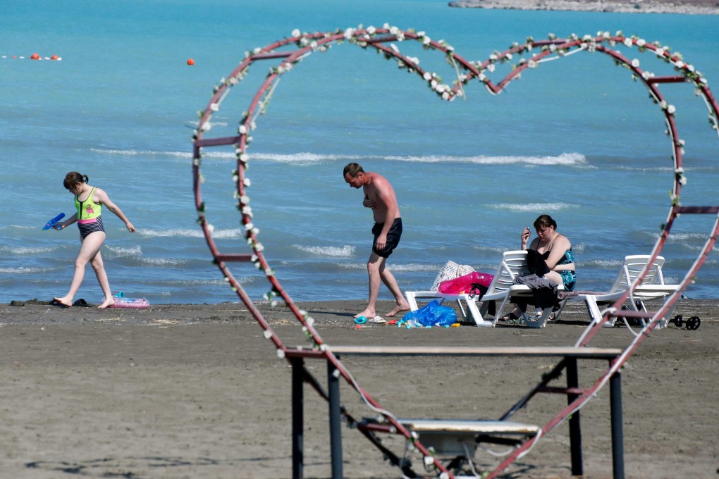 People enjoy the beach of The Golden Sands hotel and spa in Priozersk, Kazakhstan, on June 17, 2024. The former secret city on the shores of Lake Balkhash serves as the administrative centre of the Sary-Shagan missile range - built in 1956 to test anti-ballistic weapons systems and still leased by the Russian government. Photo: AFP
