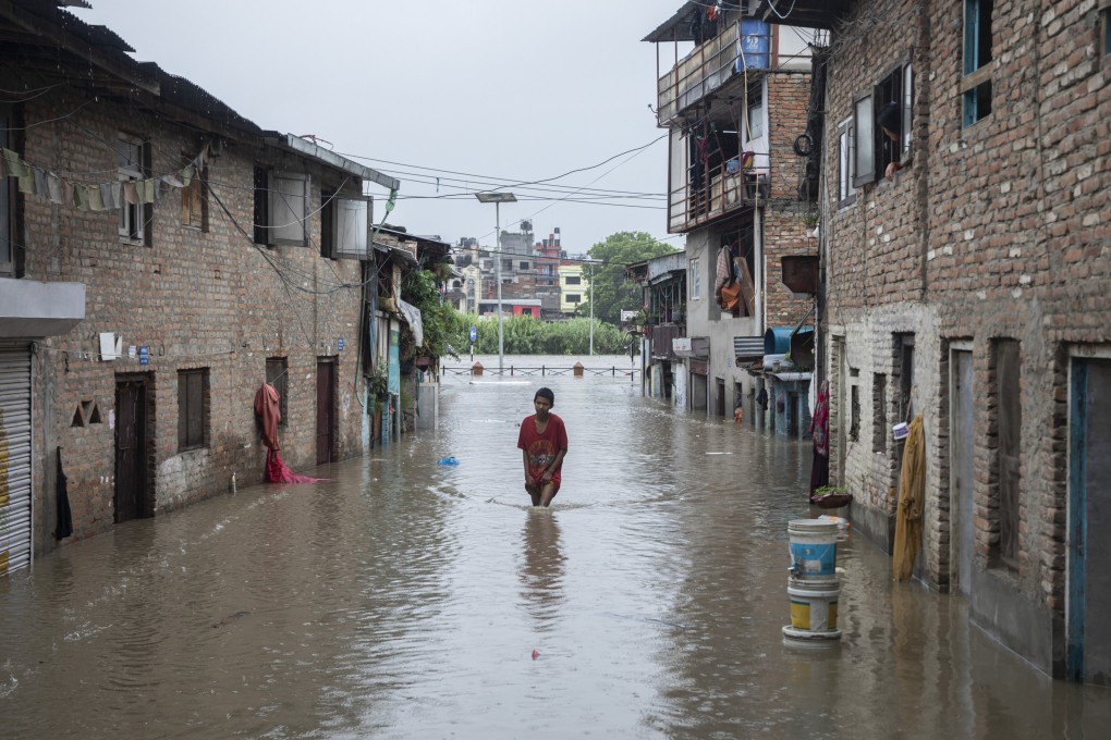 A resident wades through a flooded street after the swollen Bagmati River burst its banks in Kathmandu, Nepal. Photo: EPA-EFE