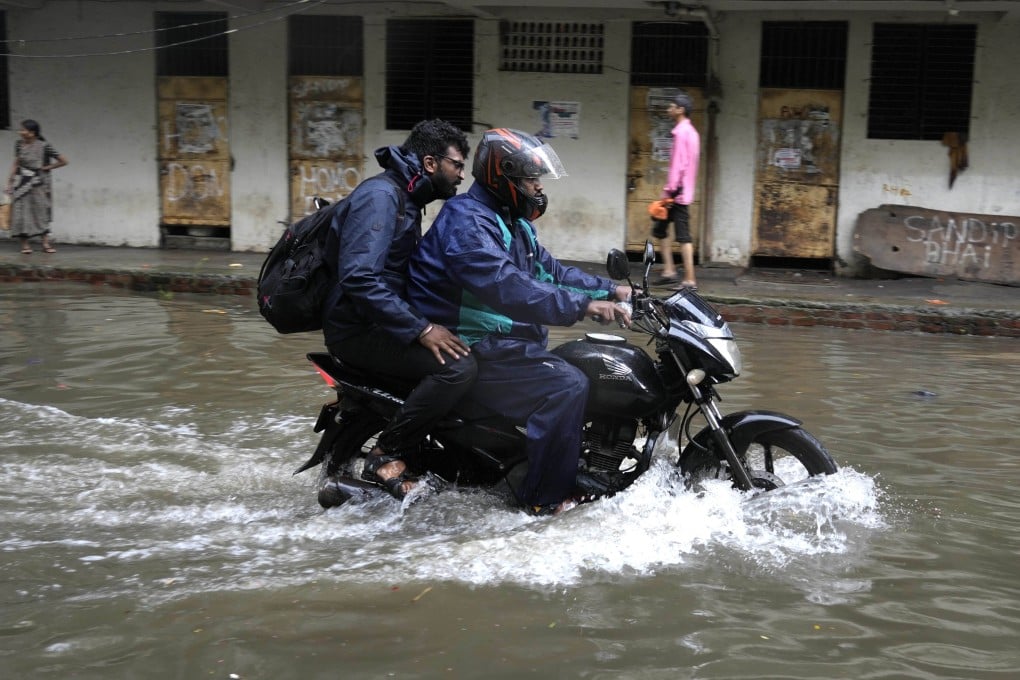 A motorcyclist drives through a flooded street after a heavy downpour, in Mumbai, India, on Monday. Photo: AP
