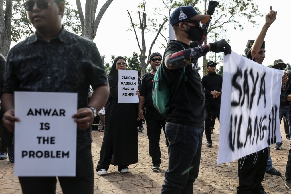 Protesters hold placards outside the Malaysian PM’s official residence in Putrajaya to demand for lower diesel prices. Photo: EPA-EFE