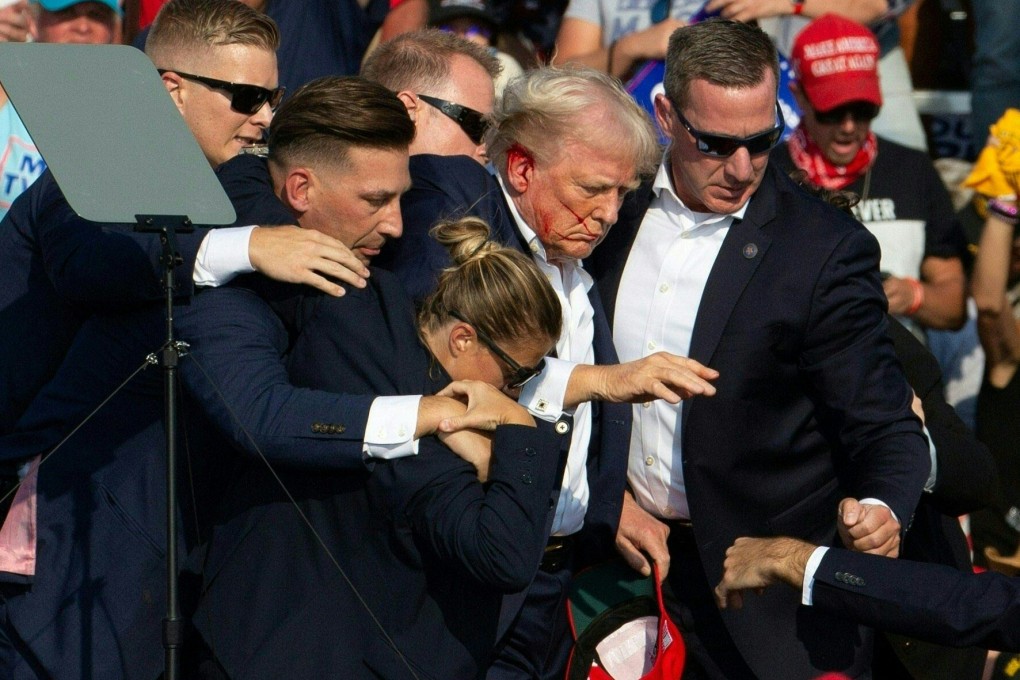 Republican presidential candidate Donald Trump is seen with blood on his face as he is escorted off the stage by Secret Service agents following the shooting at a campaign event in Butler, Pennsylvania, on Saturday. Photo: AFP