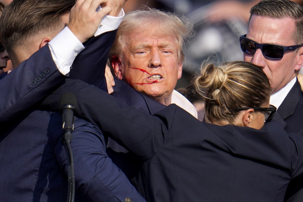 Former president Donald Trump is helped off the stage by Secret Service agents after he was shot at a rally. Photo: AP