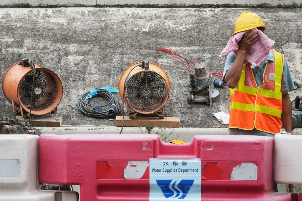 A worker uses a towel to wipe away sweat amid hot weather at a construction site in Po Lam on August 10, 2023. Photo: Elson Li