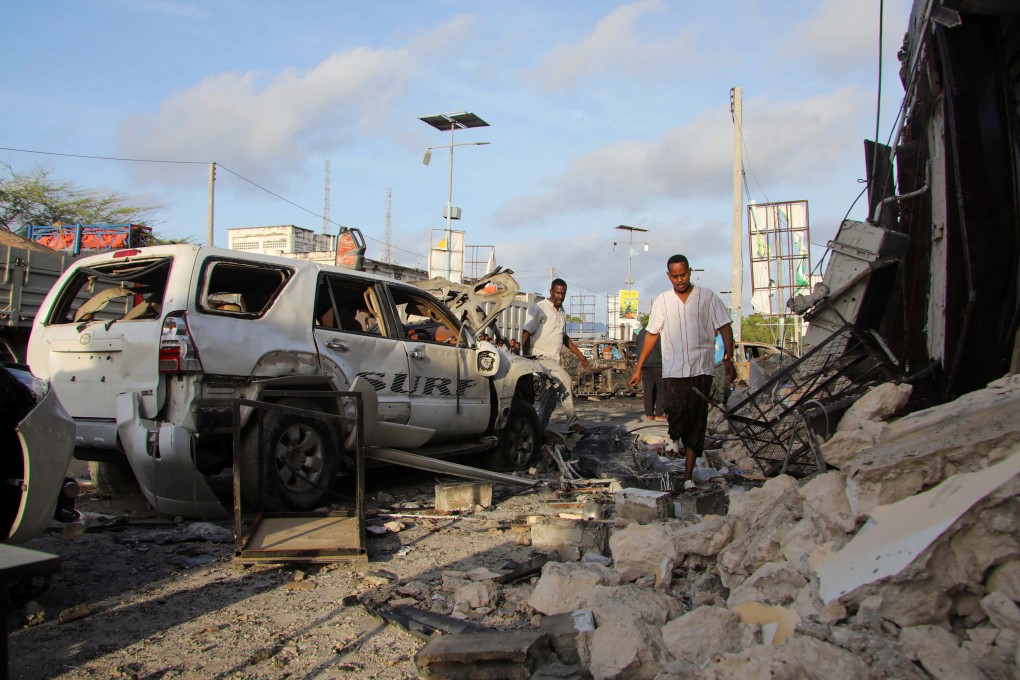 People gather near the wreckages of vehicles destroyed at the scene of an explosion outside a restaurant in Mogadishu, in which nine civilians were killed and 20 others wounded. Photo: Reuters