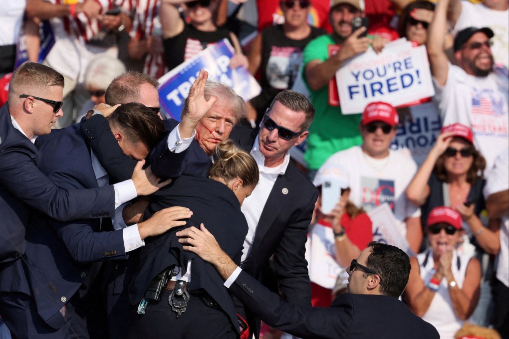 Donald Trump is escorted offstage by security officers after he was shot in the ear during a campaign rally in Butler, Pennsylvania, on Saturday. Photo: Reuters