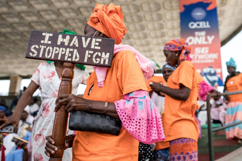 A protester against female genital mutilation holds a placard outside the National Assembly in Banjul in March, during the debate between lawmakers on a highly controversial bill seeking to lift the ban on the practice. Photo: AFP