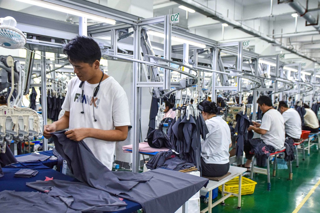 Employees work on sun protection clothing at a factory in Fuyang, in eastern China’s Anhui province, on June 27, 2024. Photo: AFP