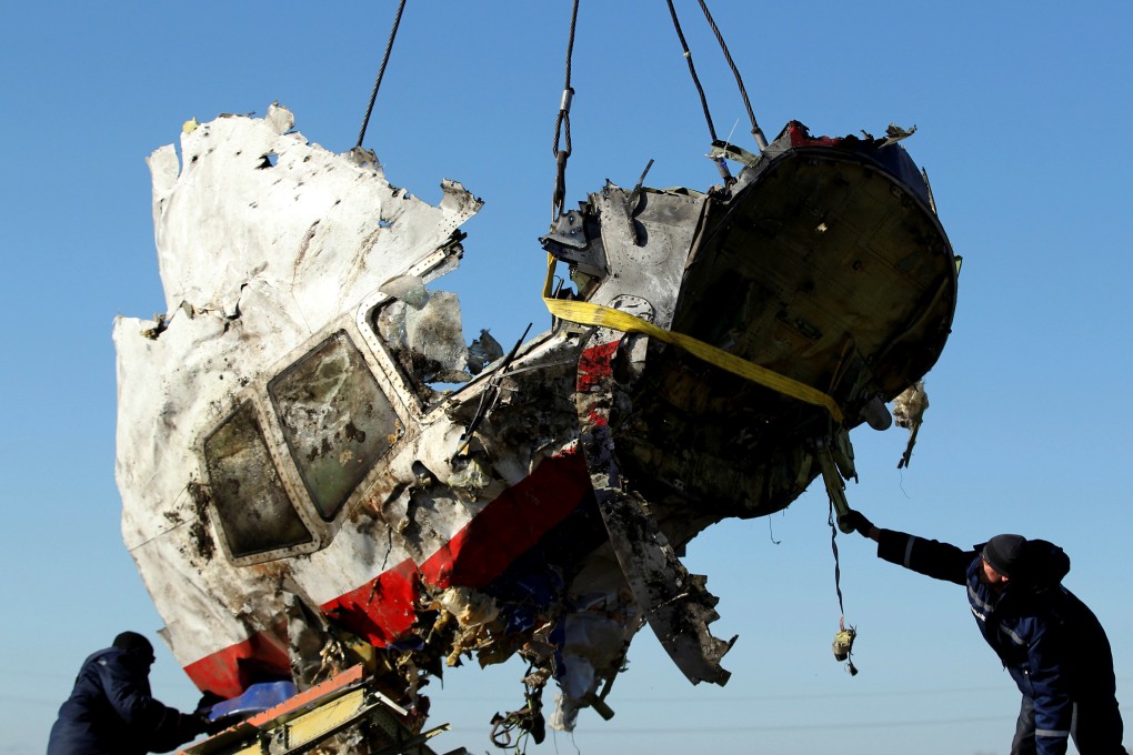 Workers transport a piece of the Malaysia Airlines flight MH17 wreckage at the site the crash in Donetsk, eastern Ukraine, in 2014. Photo: Reuters