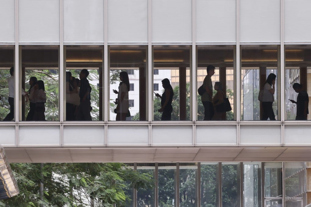 People walk on a footbridge in Central during lunch time. More than half of Hong Kong employees are at risk or struggling with respect to their finances, according to a survey by advisory firm WTW. Photo: Jelly Tse