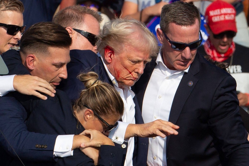 US Republican candidate Donald Trump is seen with blood on his face surrounded by secret service agents as he is taken off the stage at a campaign event in Butler, Pennsylvania, on July 13. Photo: AFP