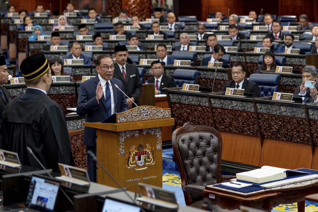 Malaysia’s Prime Minister Anwar Ibrahim, standing at center, takes his oath at the parliament in Kuala Lumpur on December 19, 2022. Photo: Prime Minister’s office via AP