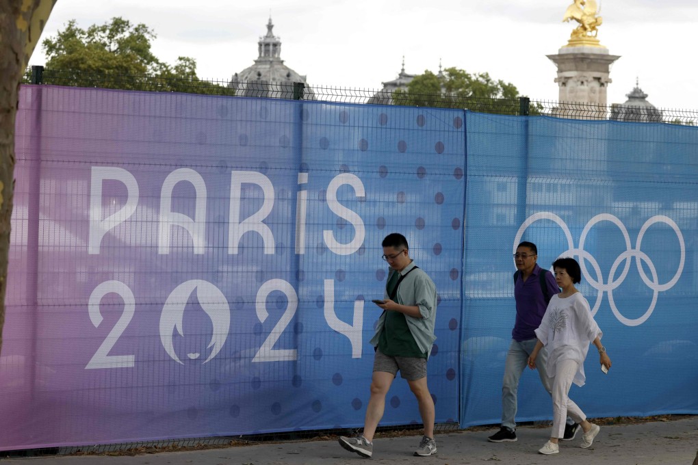 Pedestrians walk past fences erected on the Alexandre III bridge Olympic site in Paris. Photo: AFP