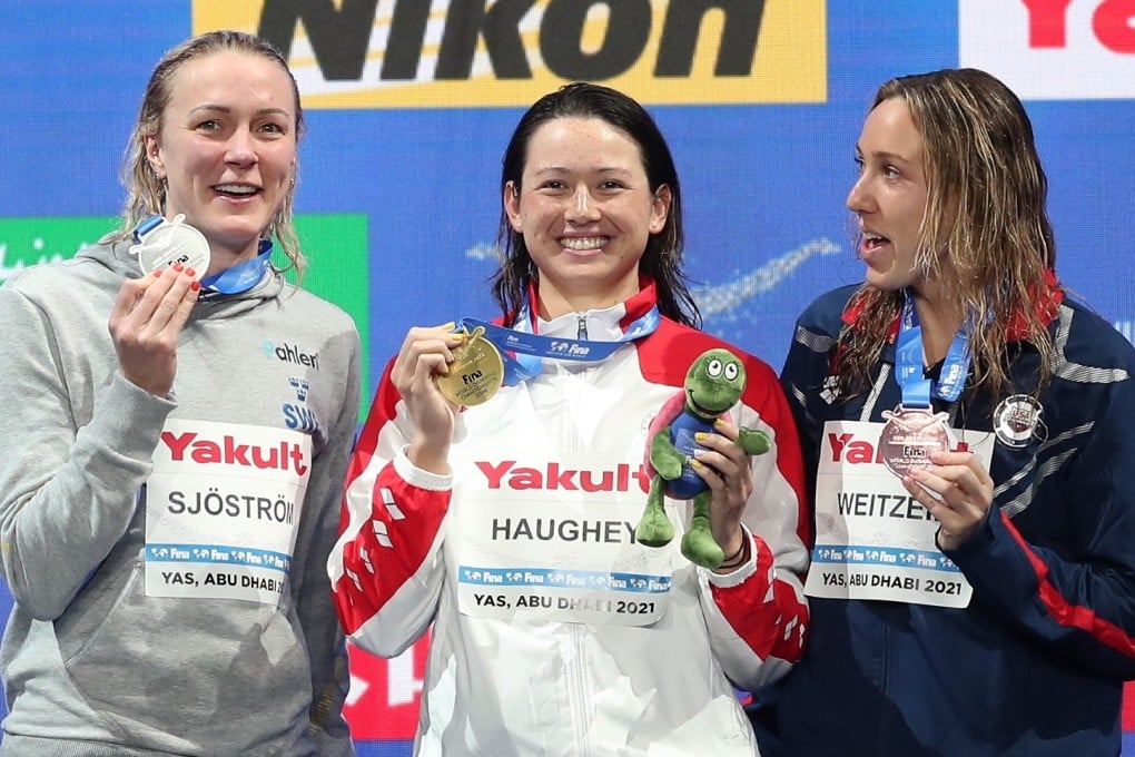 Siobhan Haughey (centre) holds up her 100m freestyle gold medal at the 2021 world short-course championships, with silver medallist Sarah Sjostrom (left) and bronze medallist Abbey Weitzeil. Photo: EPA-EFE