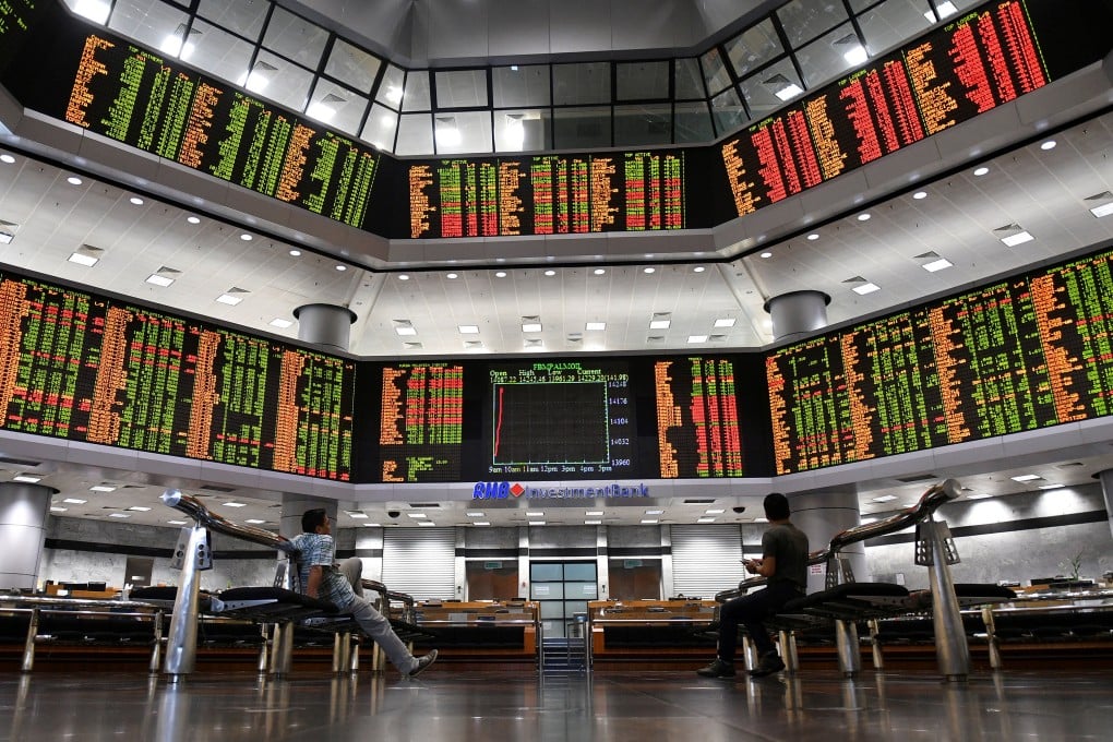 People look at trading boards at a private stock market gallery in Kuala Lumpur. Malaysia’s benchmark KLCI is hovering near three-and-a-half-year highs. Photo: Reuters