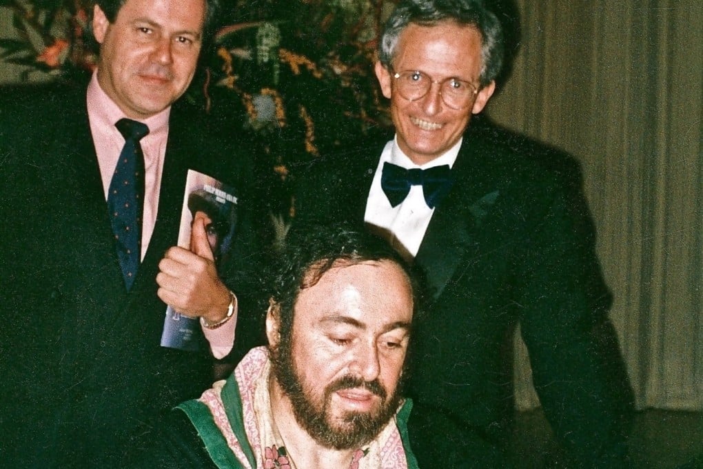 Luciano Pavarotti signs autographs following his first concert in Hong Kong, in February 1990. In his memoir, John Duffus (right) recalls the time Pavarotti sang a duet with Jiang Zemin in Beijing. Photo courtesy of Blacksmith Books
