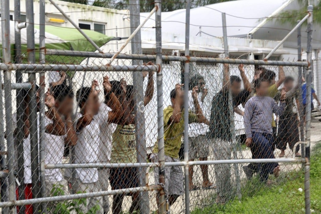 A file picture dated March 2014 shows asylum seekers behind a fence at the Manus Island detention centre in Papua New Guinea. Australia and PNG agreed to close the detention centre following a decision by the PNG Supreme Court declaring it unconstitutional, but many refugees still remain there. Photo: EPA