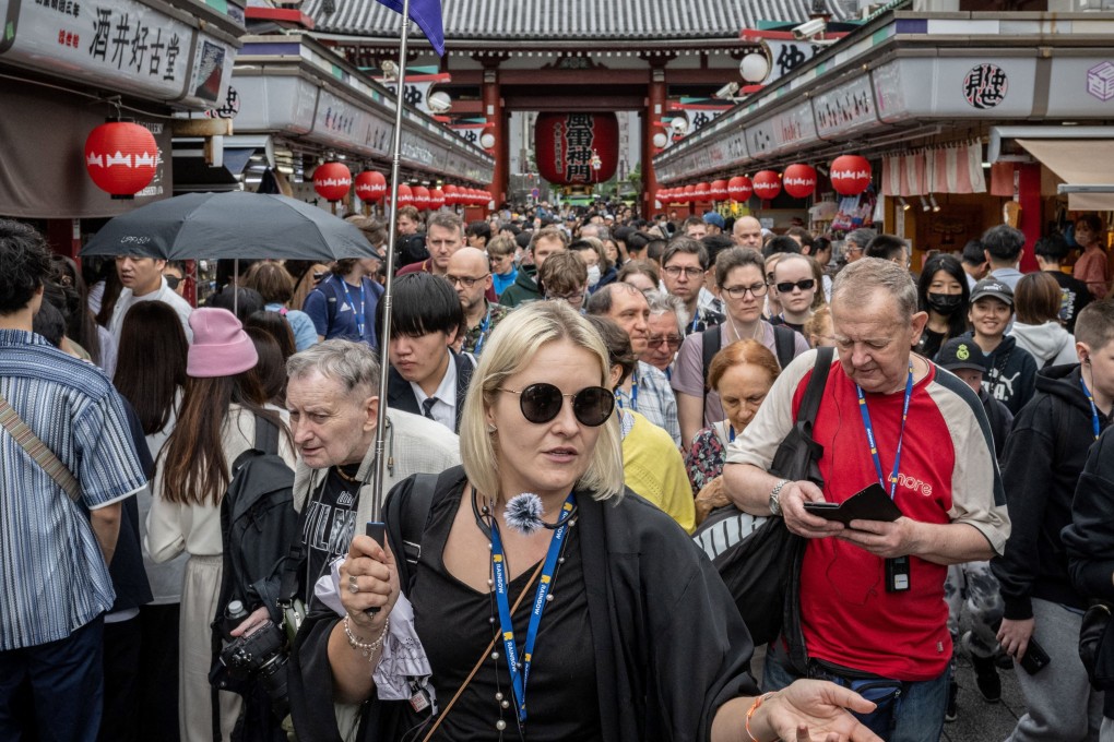 Tourists on Nakamise-dori, a shopping street near Sensoji Temple in Tokyo, in 2024. In Japan, a growing number of restaurant and attraction operators are looking at charging foreign visitors more than residents. Photo: AFP