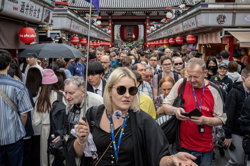 Tourists on Nakamise-dori, a shopping street near Sensoji Temple in Tokyo, in 2024. In Japan, a growing number of restaurant and attraction operators are looking at charging foreign visitors more than residents. Photo: AFP