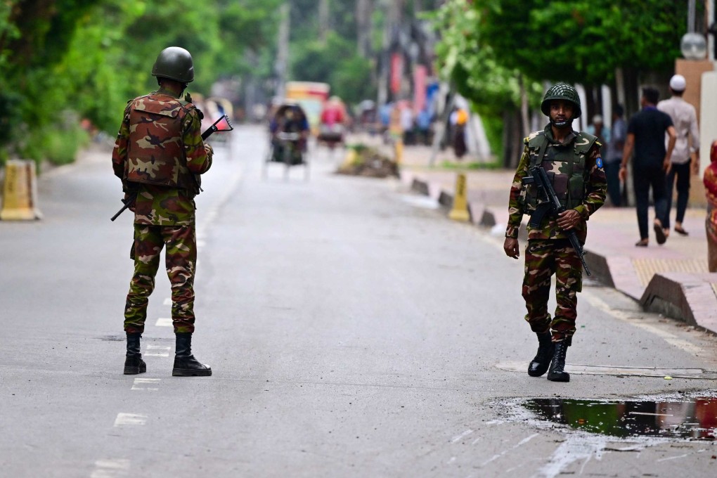 Bangladeshi soldiers stand guard along a street during a curfew amid the anti-quota protests, in Dhaka on Monday. Photo: AFP