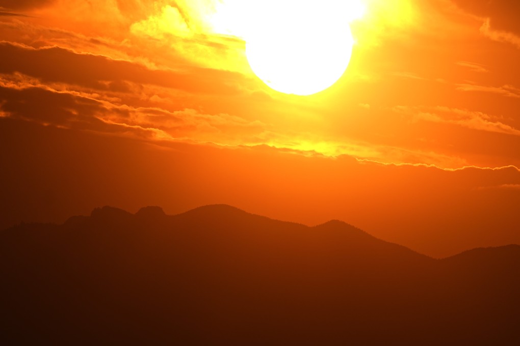 The setting sun illuminates the clouds over the Rocky Mountains. The World set a milestone for hottest day ever recorded for the second straight day. Photo: AP