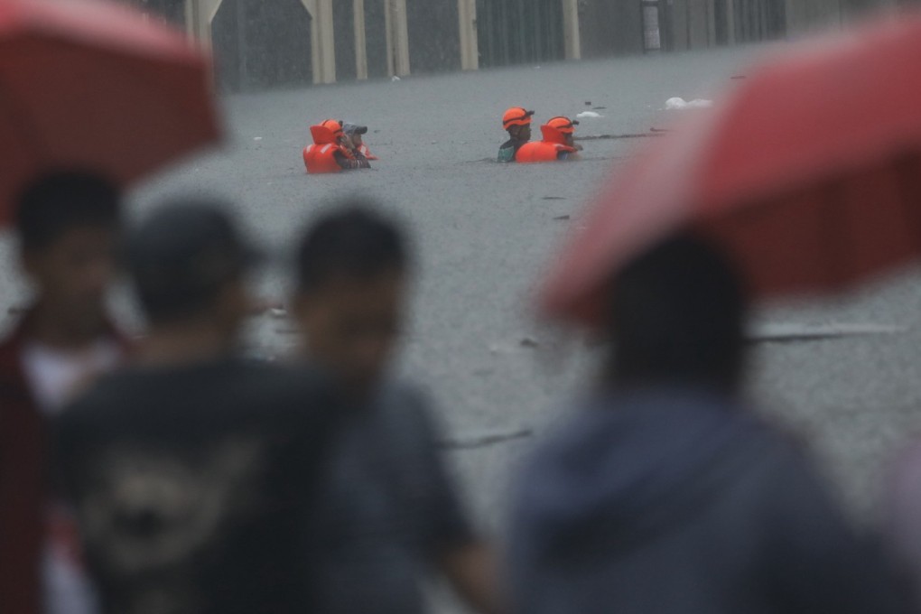 Rescuers walk through chest-deep flood waters in Quezon City, Metro Manila, on Wednesday amid monsoon rains supercharged by Typhoon Gaemi off the Philippines’ coast. Photo: EPA-EFE