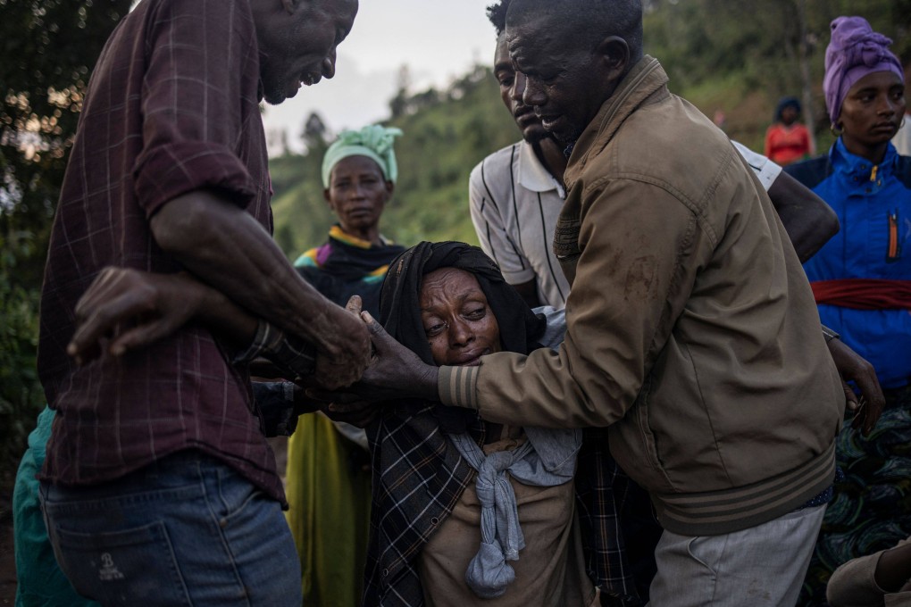 A woman is comforted by relatives and friends while residents and volunteers leave for the night after digging in the mud in search for survivors and bodies at the scene of a landslide in Ethiopia. Photo: AFP