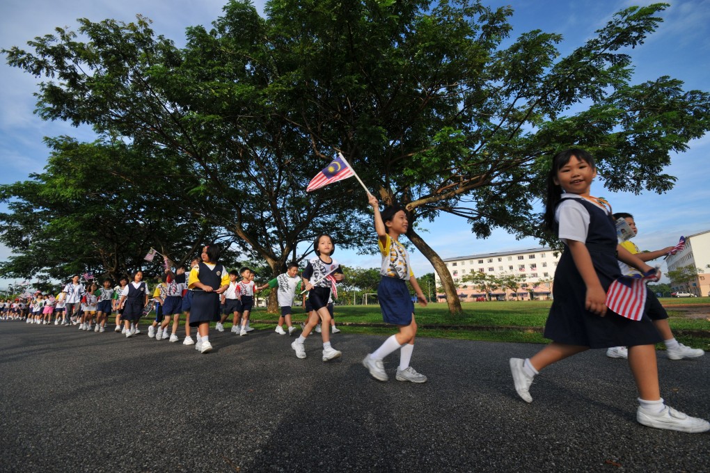 Malaysian school children waving the national flag. National schools in Malaysia teach in Malay and English while vernacular schools offer lessons in Mandarin and Tamil. Photo: Malaysian Chinese Association