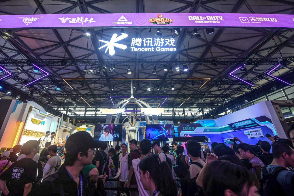 ChinaJoy attendees pass in front of Tencent Holdings’ exhibition space at the opening of the annual digital entertainment expo on Friday in Shanghai. Photo: AFP