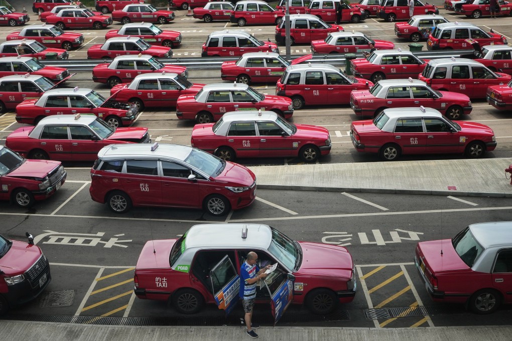 A taxi driver reads a newspaper while waiting in line to pick up passengers at Hong Kong International Airport on July 15. Photo: Elson Li