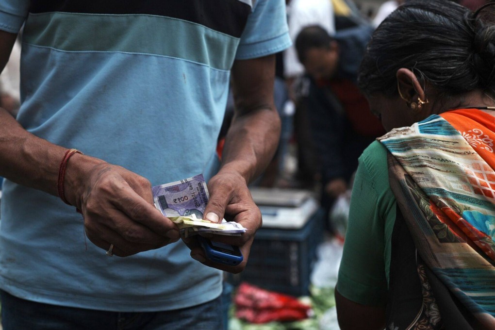 A market vendor counts money in Mumbai. Modi’s government pledged billions to boost jobs and improve education in India, while also targeting a smaller fiscal deficit. Photo: Bloomberg