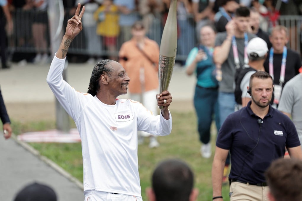 US rapper Snoop Dogg holds the torch as part of the 2024 Paris Olympic Games Torch Relay. Photo: Reuters
