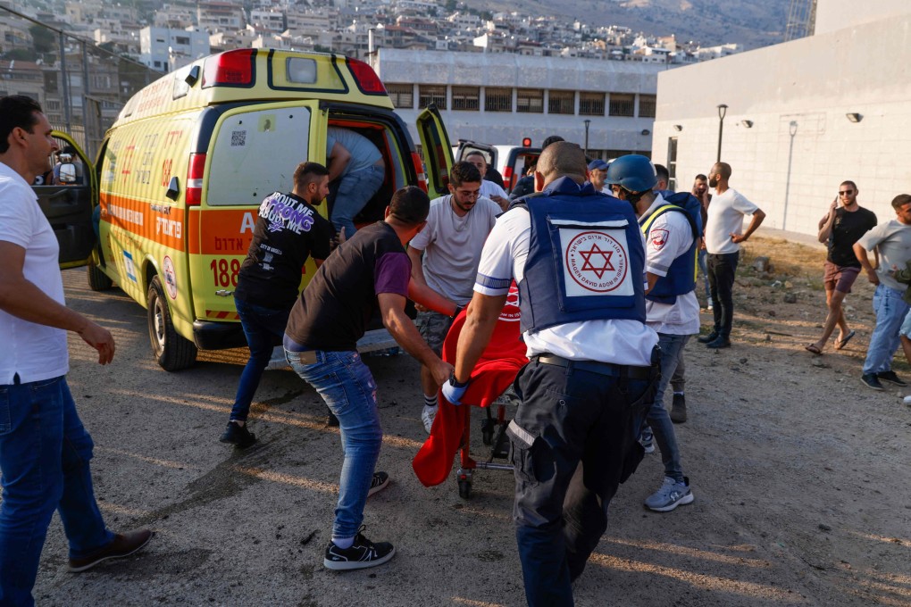 Israeli security forces and medical workers transport casualties from the site of a rocket strike in the Israeli-annexed Golan area on Saturday. Photo: AFP