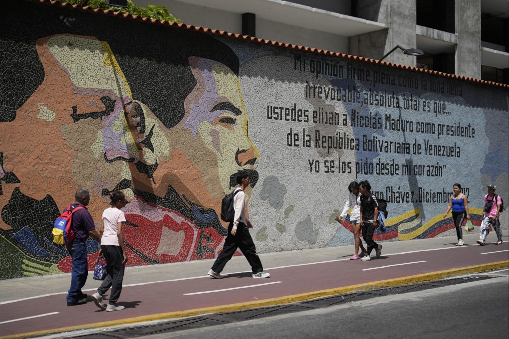 People walk past in front of a mural of late Venezuelan President Hugo Chavez and Venezuelan President Nicolas Maduro in Caracas. Photo: AP