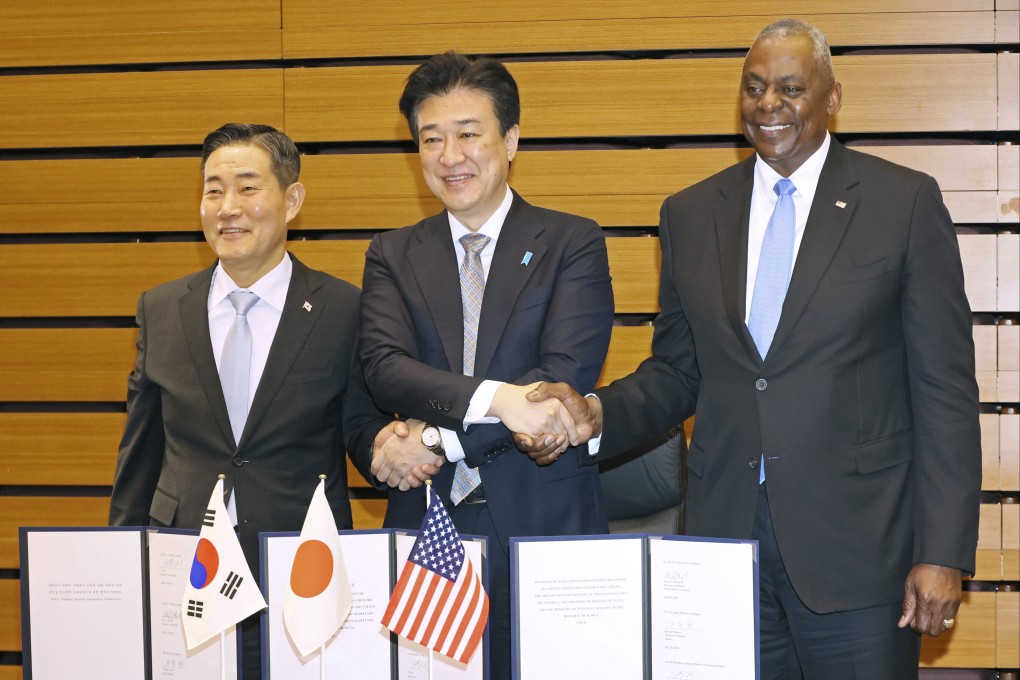 (From left) South Korean Defence Minister Shin Won-sik, Japanese Defence Minister Minoru Kihara and US Secretary of Defence Lloyd Austin shake hands after a trilateral defence ministers’ meeting in Tokyo on Sunday. Photo: Pool via AP