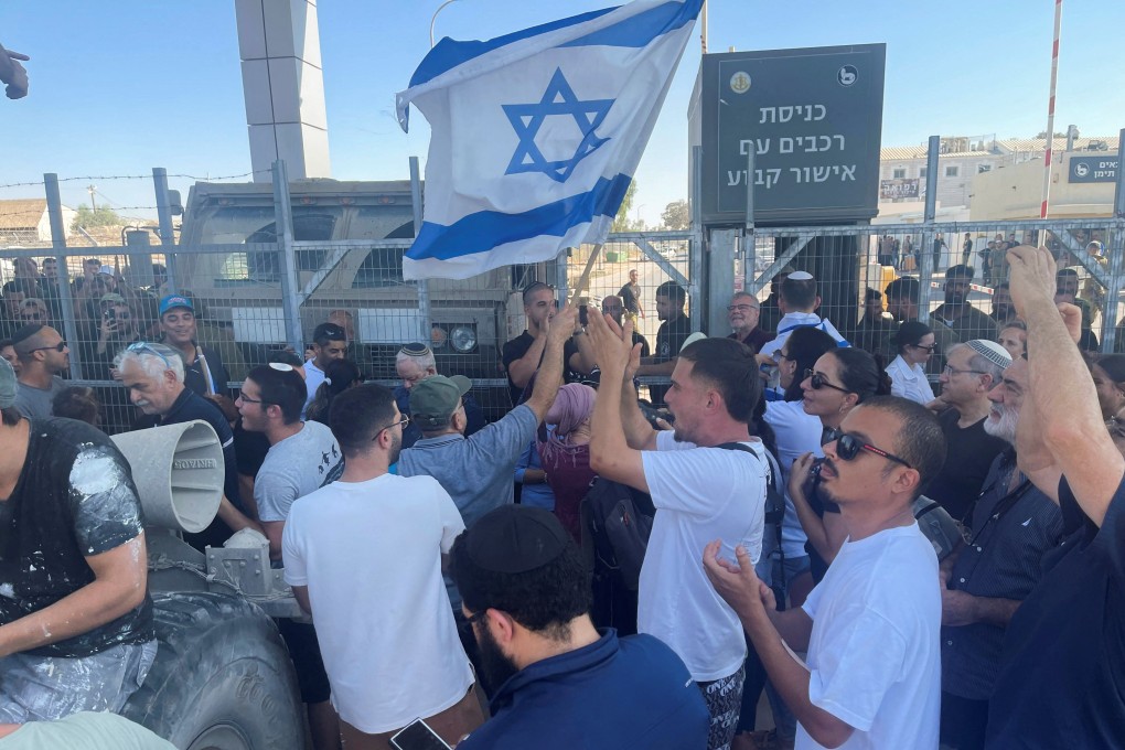 Right-wing protesters wave Israeli flags outside Sde Teiman detention facility. Photo: Reuters